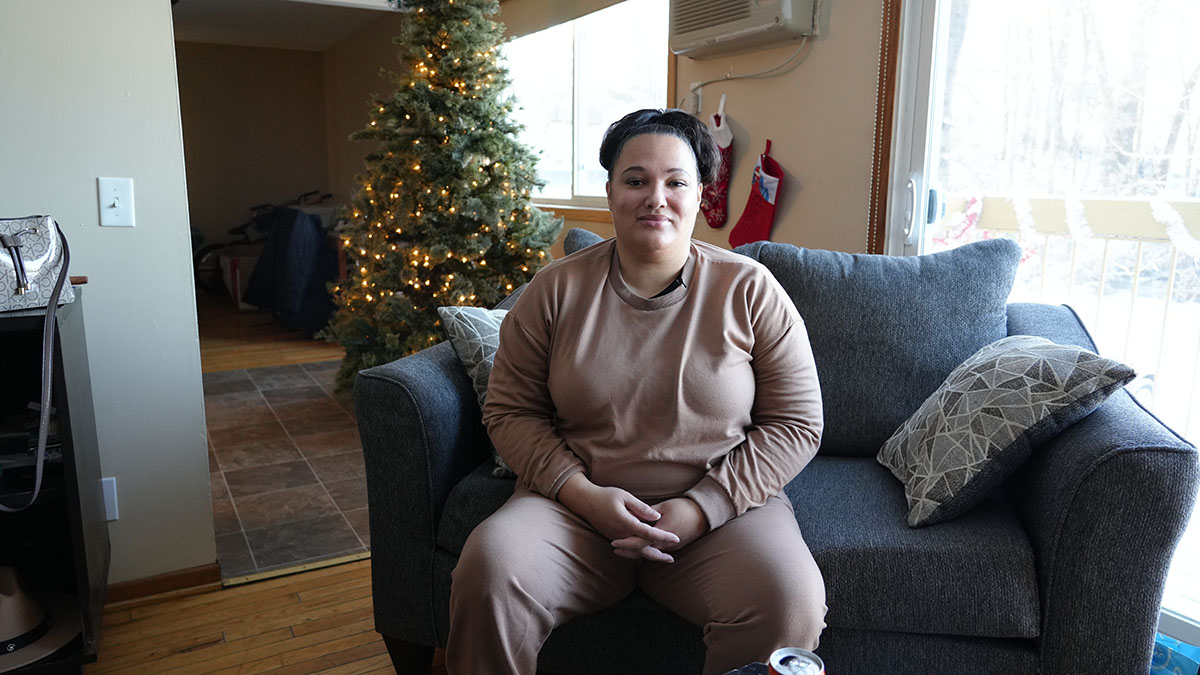 Woman sitting on couch in front of Christmas tree