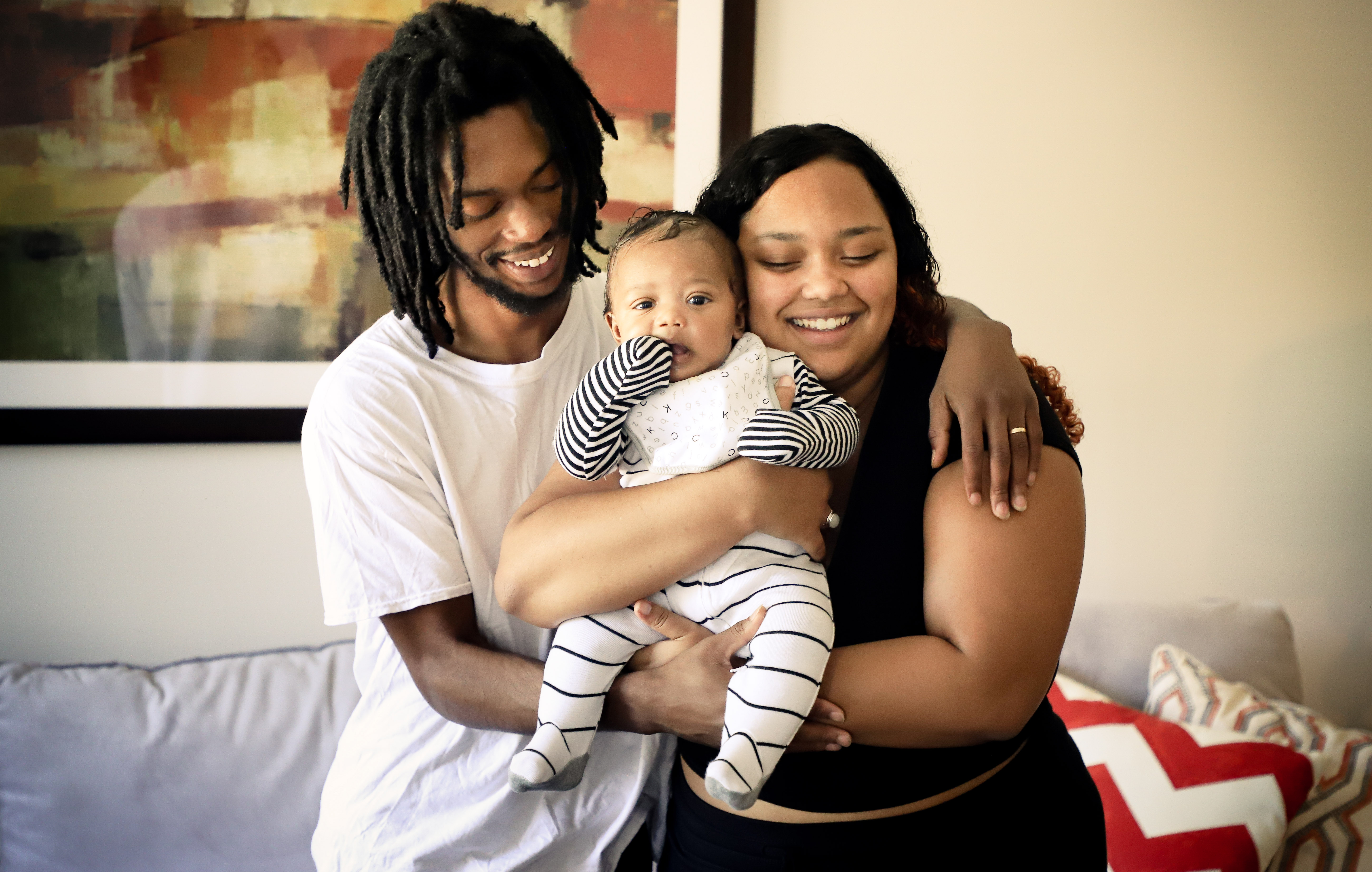 Black couple holding a baby