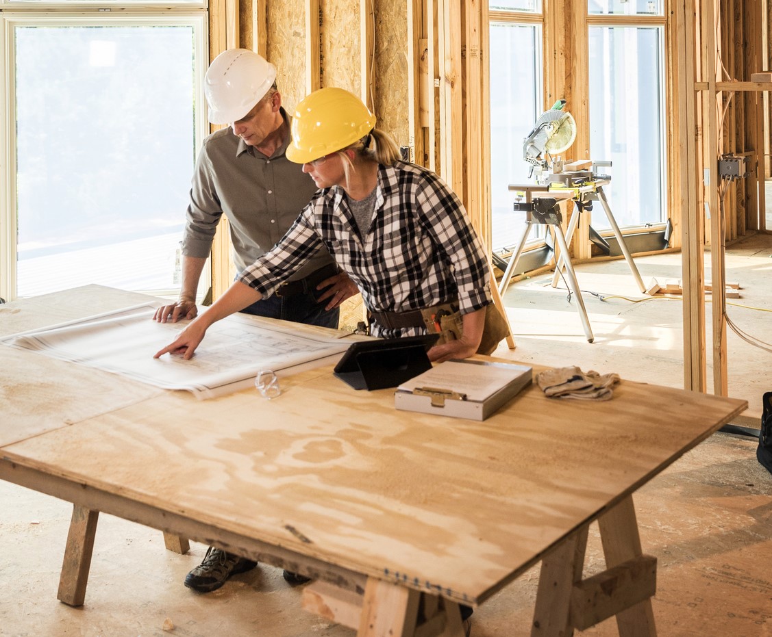 Two construction workers looking at blueprints