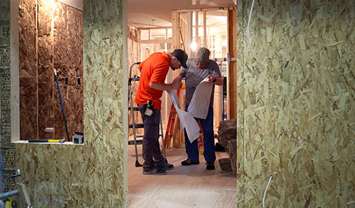 Men looking at plans in house being built