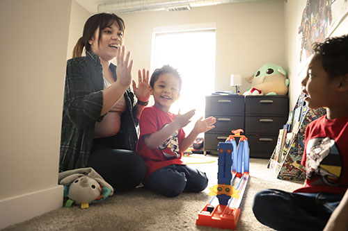 Woman and two children playing on floor