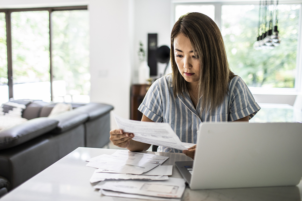 Woman_with_computer_looking_at_bills